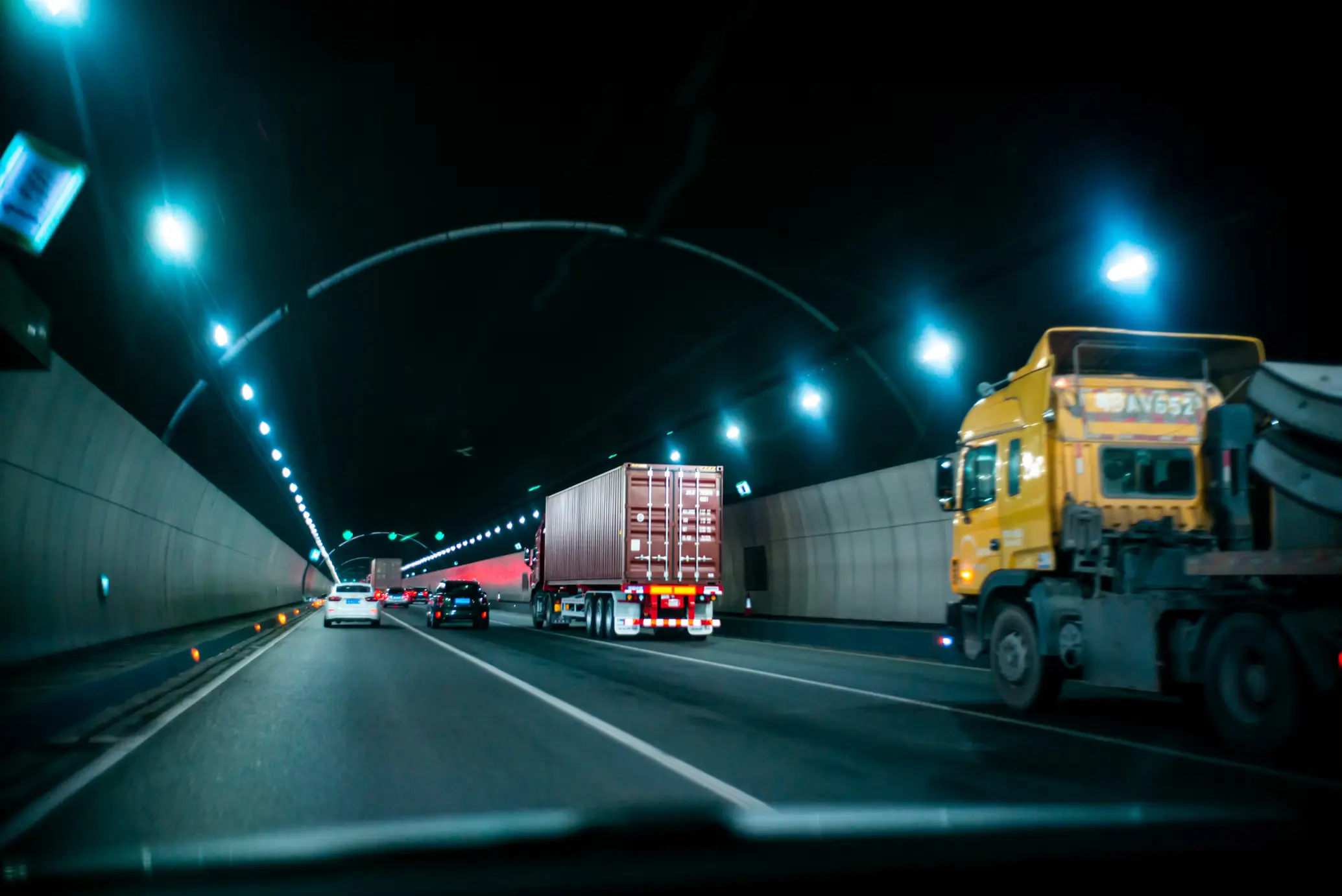 Camión y tractocamión circulando debajo de tunel